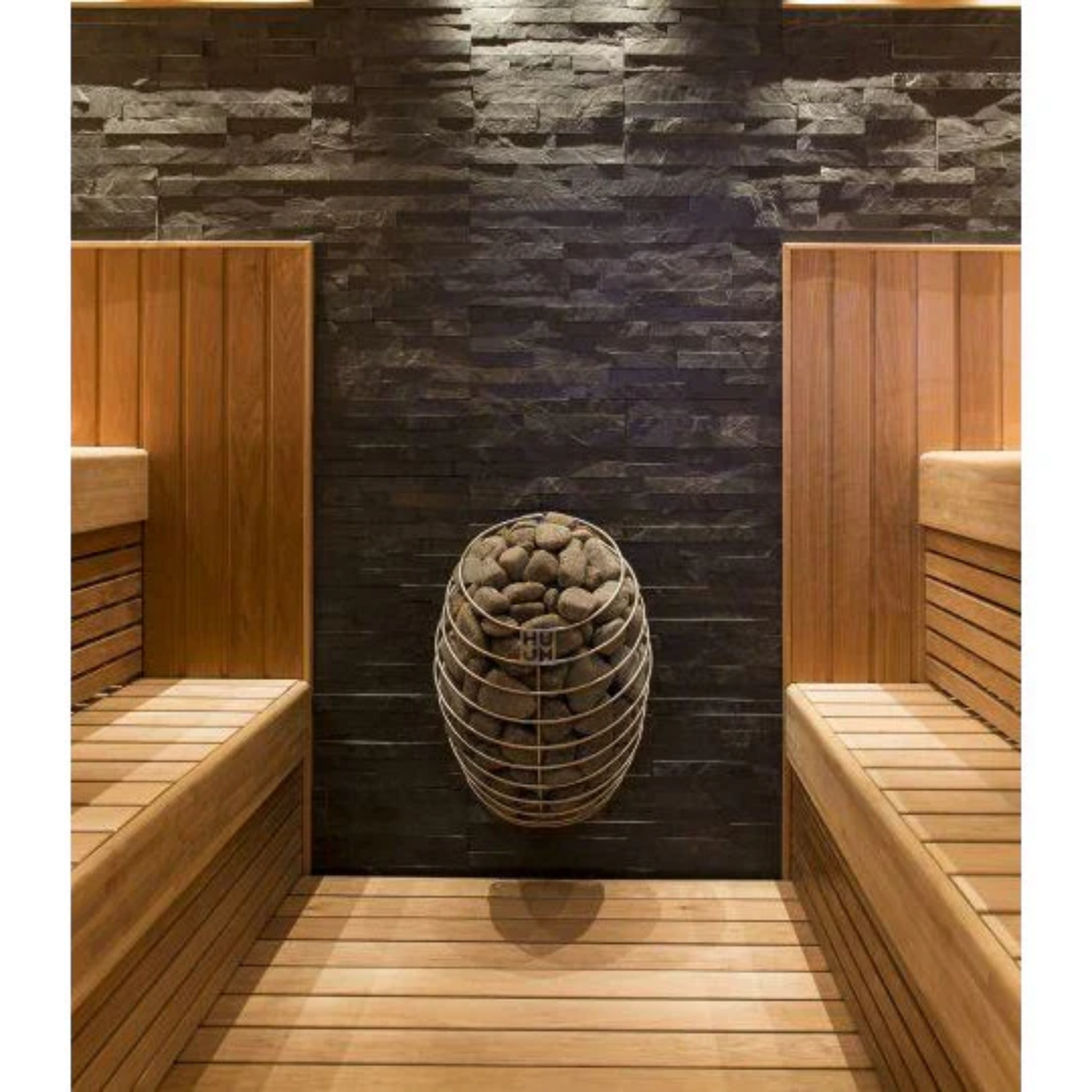A wall-mounted electric sauna heater with a sleek, rounded design and stainless steel details, filled with sauna stones.