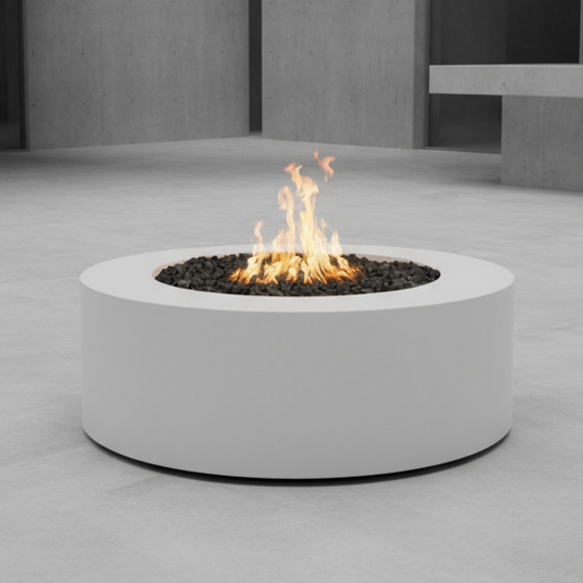 Round concrete white fire pit with flames on a gray concrete floor.
