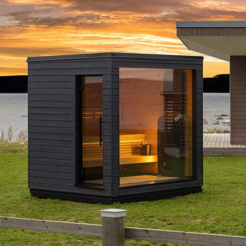 Modern outdoor sauna with a scenic sunset background