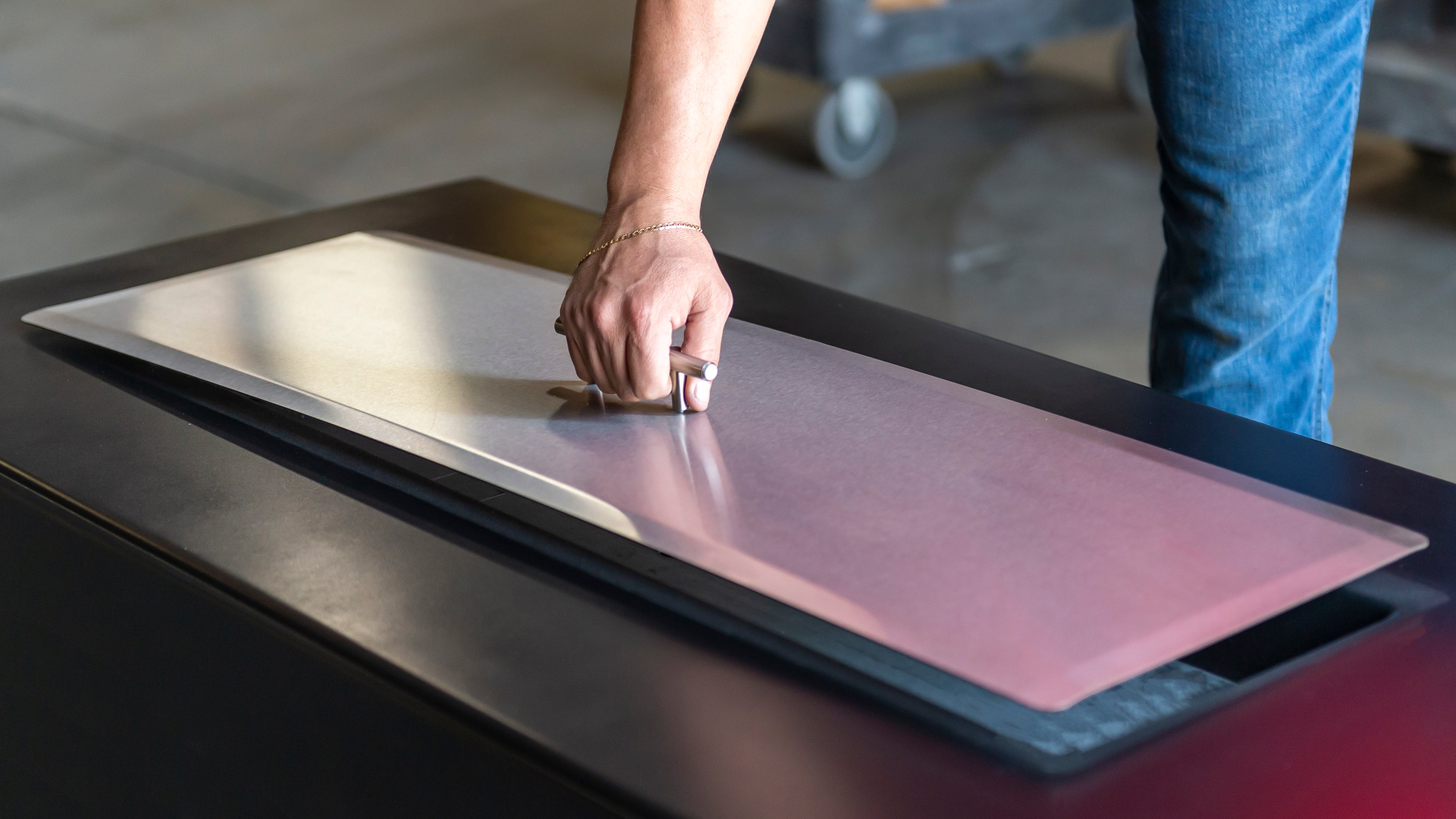 Fire pit table lid or cover being placed on top of a fire pit table