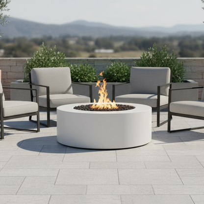 Outdoor patio with round white fire pit table and chairs on a sunny day