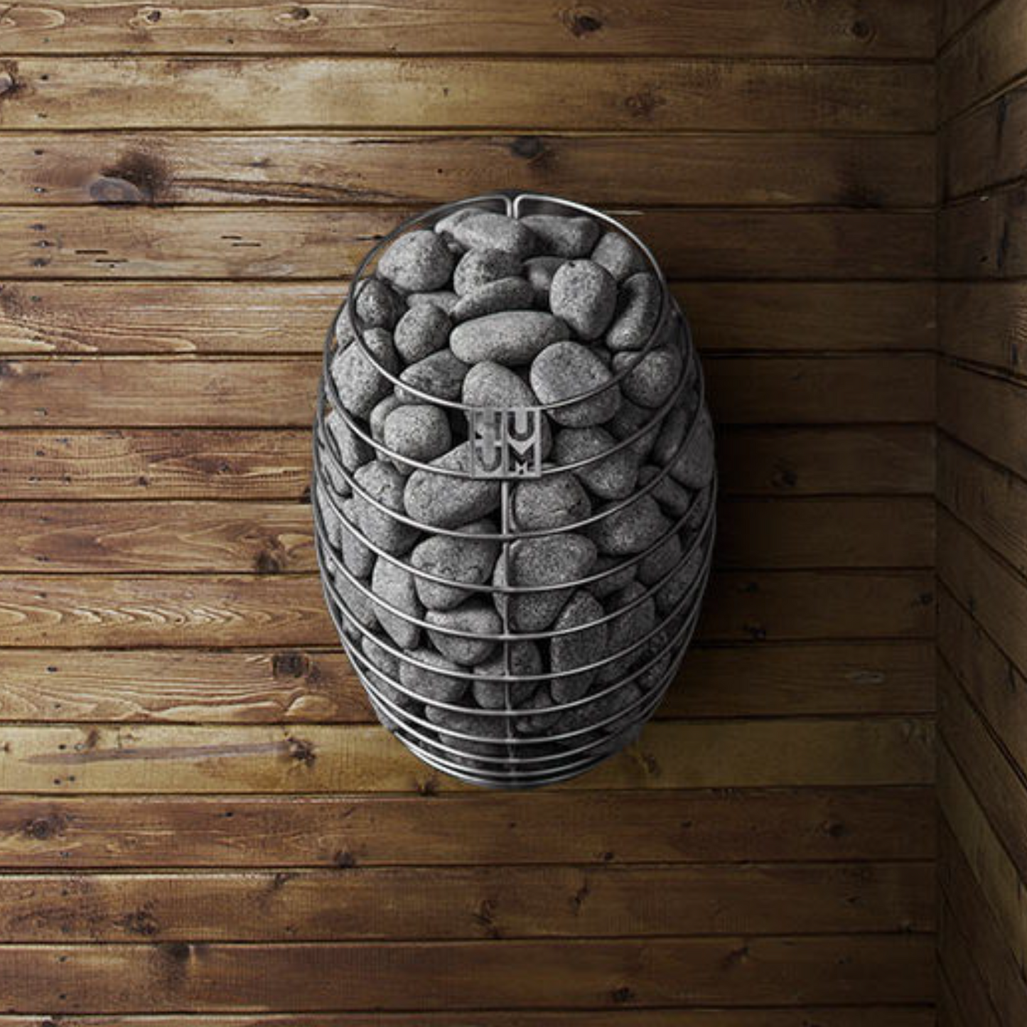 HUUM DROP sauna heater filled with stones against a wooden wall